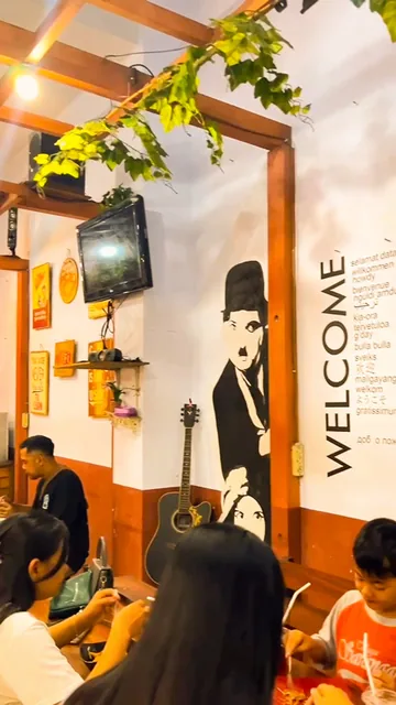 Guests dining inside Waroeng Mr. Mizo near the welcome wall